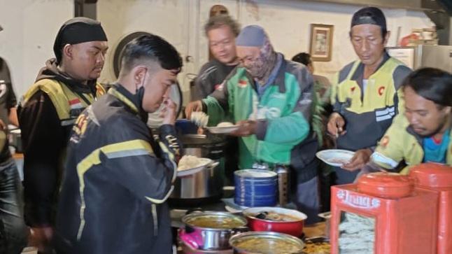 Pengemudi ojol menikmati makan gratis yang diadakan relawan Prabowo-Gibran GN 08. (istimewa)