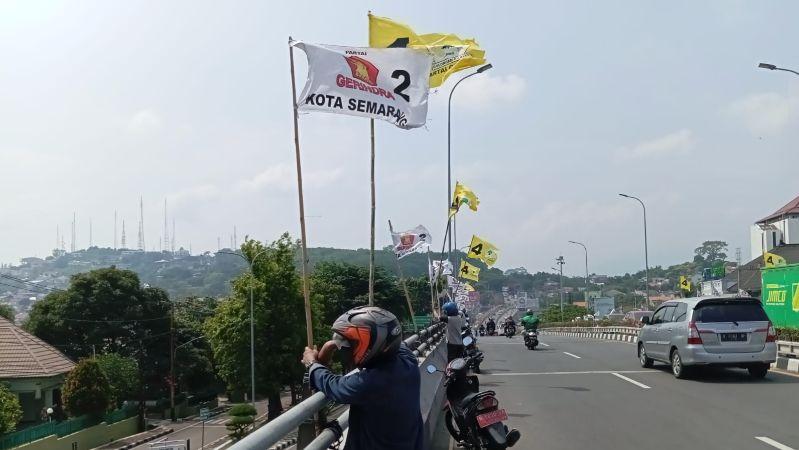 Petugas menertibkan alat peraga kampanye yang melanggar aturan di flyover Jatingaleh. (istimewa)