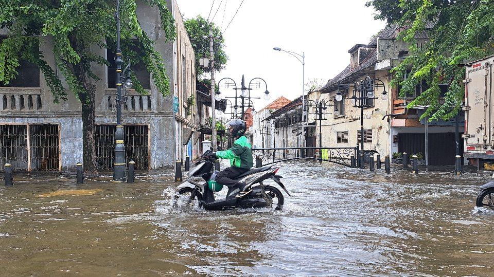 Pengendara sepeda motor melintasi banjir Jalan Empu Tantular, Kawasan Kota Lama Semarang. (baihaqi/jatengtoday.com)