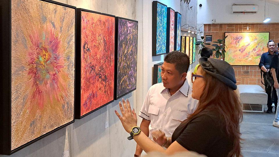 Pelukis Fiya Ardia sedang berbincang dengan Mualim di pameran tunggalnya. (baihaqi/jatengtoday.com)