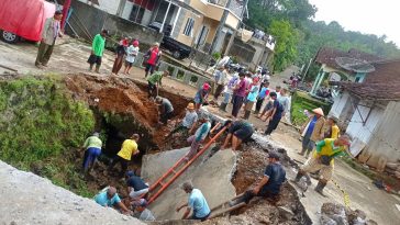 Mahasiswa KKN bersama warga sedang gotong royong membersihkan material longsor di Kebondalem. (istimewa)