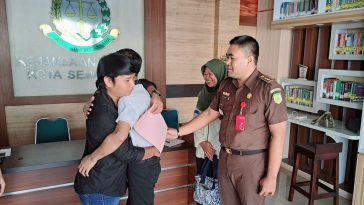 Kasi Pidum Kejari Kota Semarang, Sarwanto menyaksikan tersangka dan korban penganiayaan berpelukan. (baihaqi/jatengtoday.com)