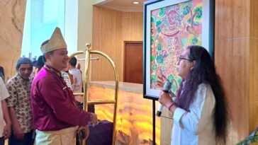 Sekretaris Disbudpar Kota Semarang, Samsul Bahri (kiri) mendengar penjelasan karya yang dipamerkan di Grand Candi Hotel Semarang, Selasa (21/4/2026). (baihaqi/jatengtoday.com)